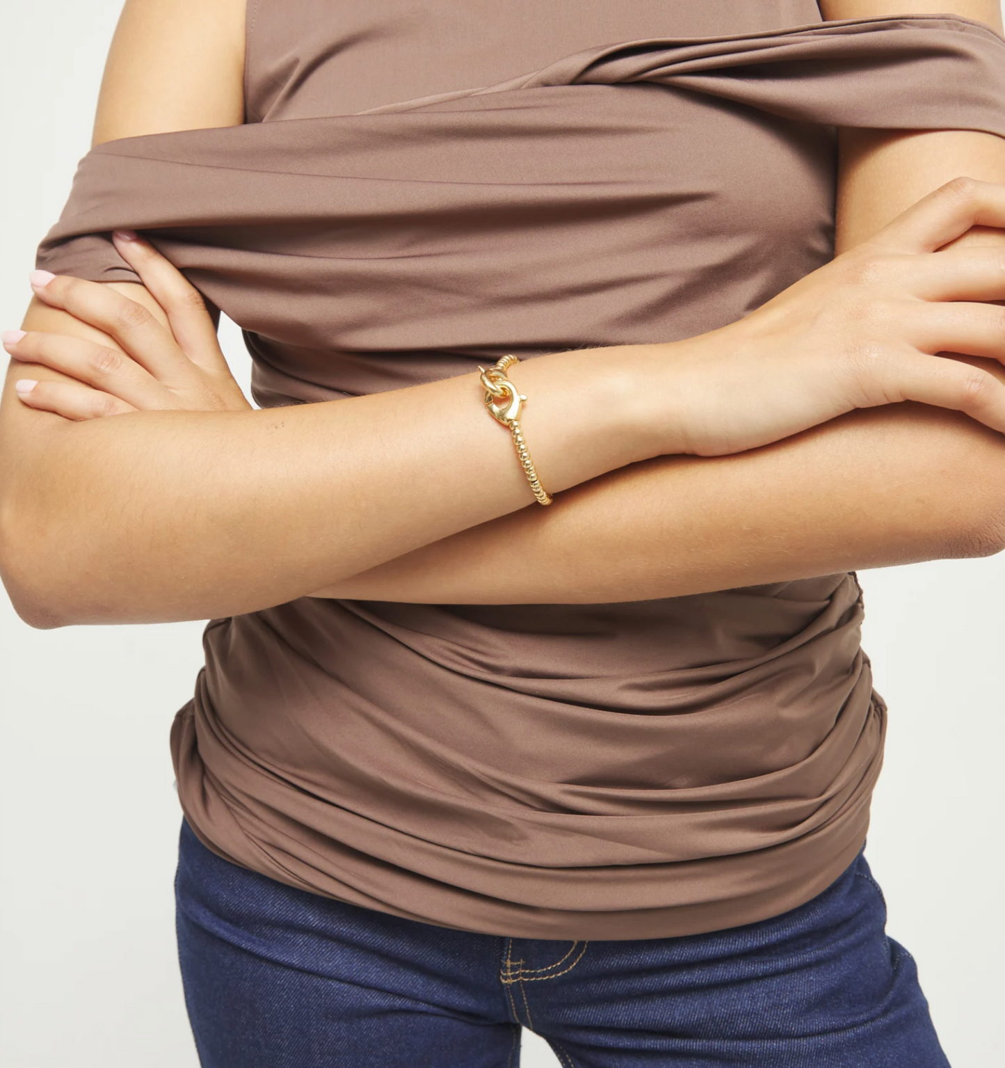 Pulsera de bolas pequeñas bañada en oro con mosquetón entrelazado