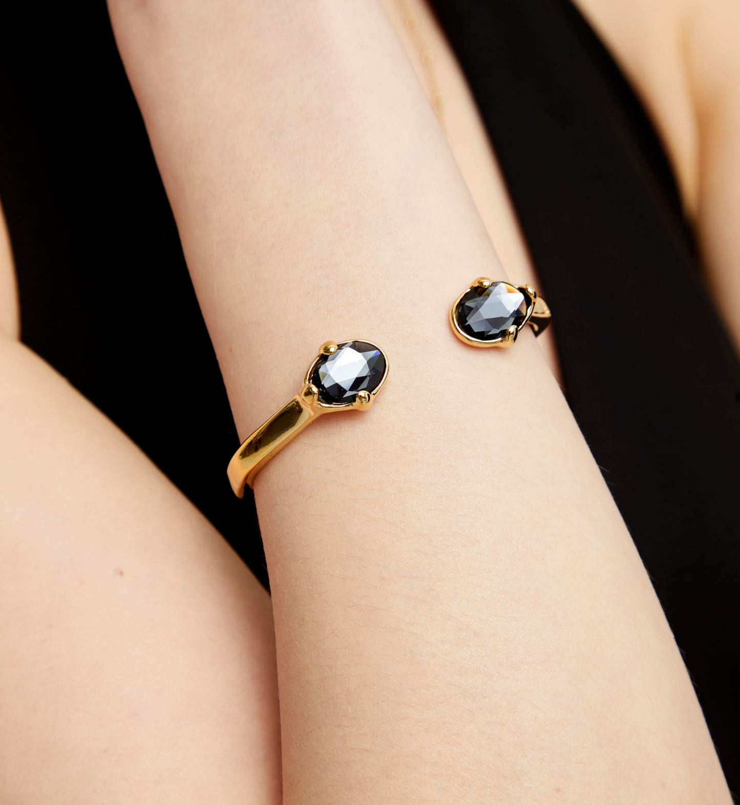 Pulsera rígida bañada en oro 18k con dos cristales facetados ovalados negros