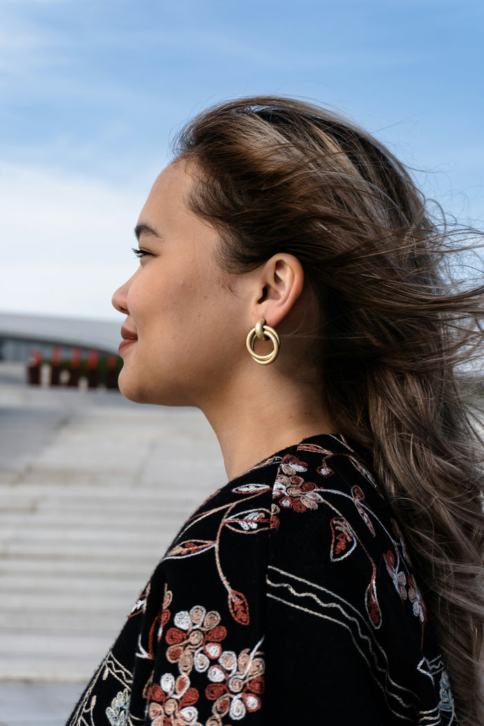 Woman with windblown hair and gold earrings