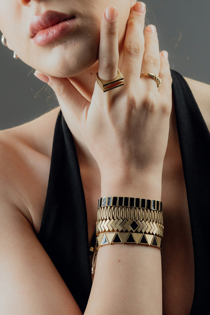 Stacked gold bracelets and rings
