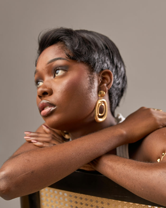 Woman with short dark hair and golden earrings